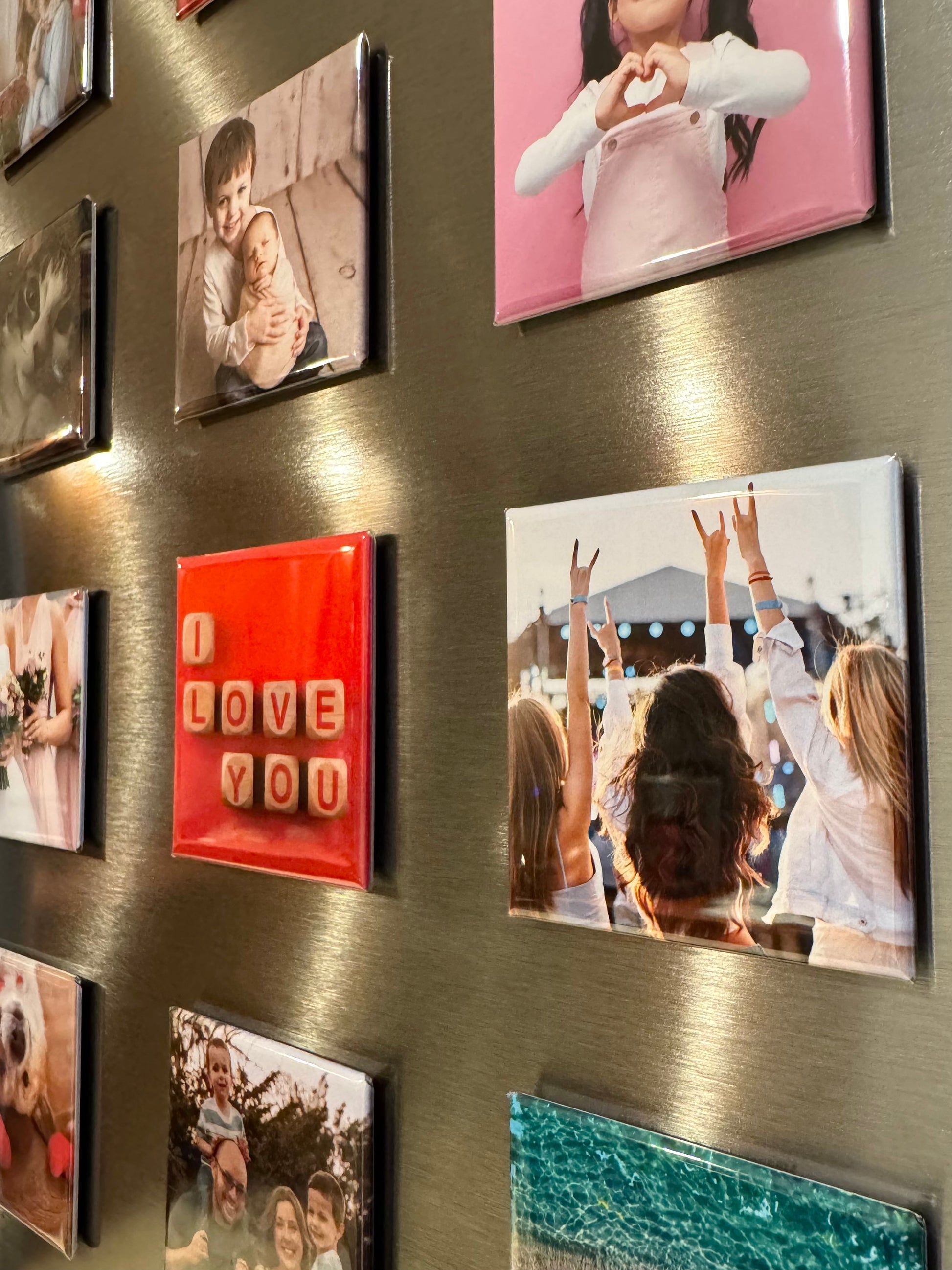 Fridge with various photo magnets and a red square magnet with 'I LOVE YOU' text. One photo magnet shows friends at a concert.