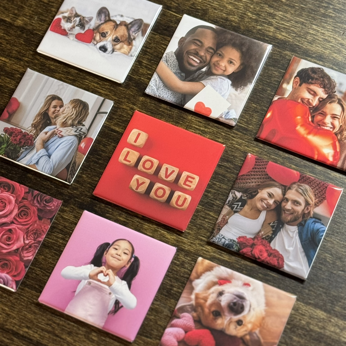 Nine square magnets laid side by side. The magnets show various images including a father and daughter embracing, happy couples, pets, vibrant roses and an image that says "I love you".