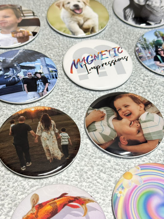 Collection of round personalized photo magnets with various images on a metal surface.